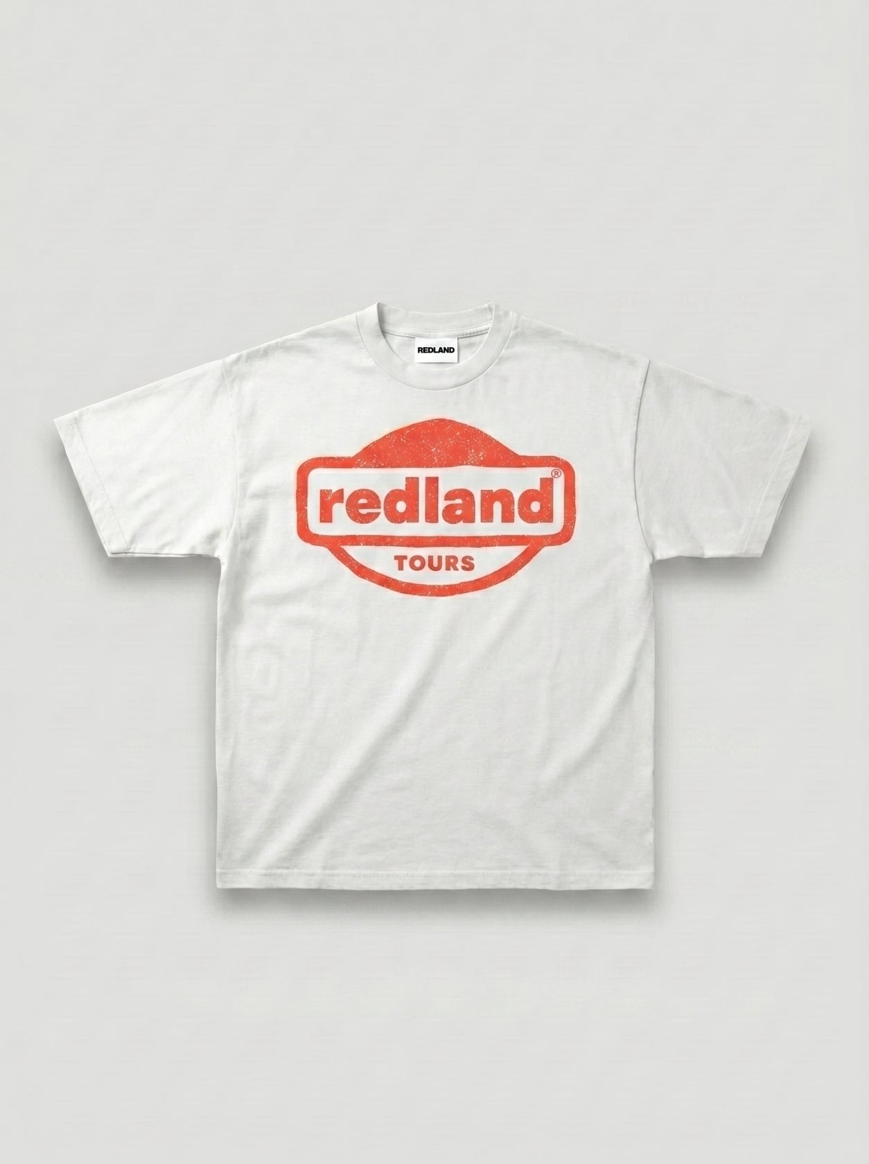 T-shirt bianca con logo rosso Redland Tours effetto timbro.