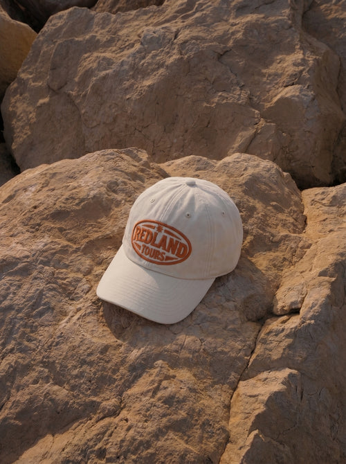 Cappellino beige Redland Tours con logo ovale ricamato arancio.