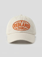 Cappellino beige Redland Tours con logo ovale ricamato arancio.