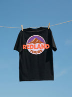 T-shirt nera Redland Tours con grafica mountain badge sul retro.