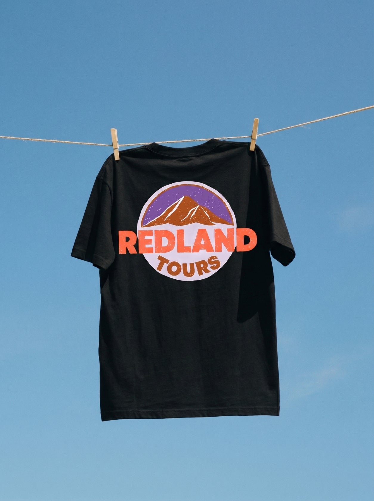 T-shirt nera Redland Tours con grafica mountain badge sul retro.