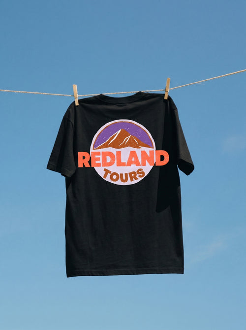 T-shirt nera Redland Tours con grafica mountain badge sul retro.