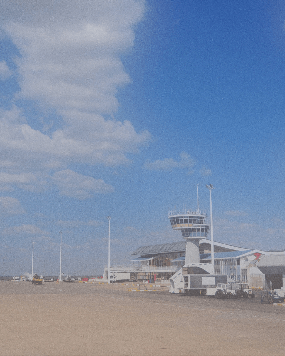 Aeroporto con torre di controllo sotto cielo azzurro, punto di partenza per tour in Namibia
