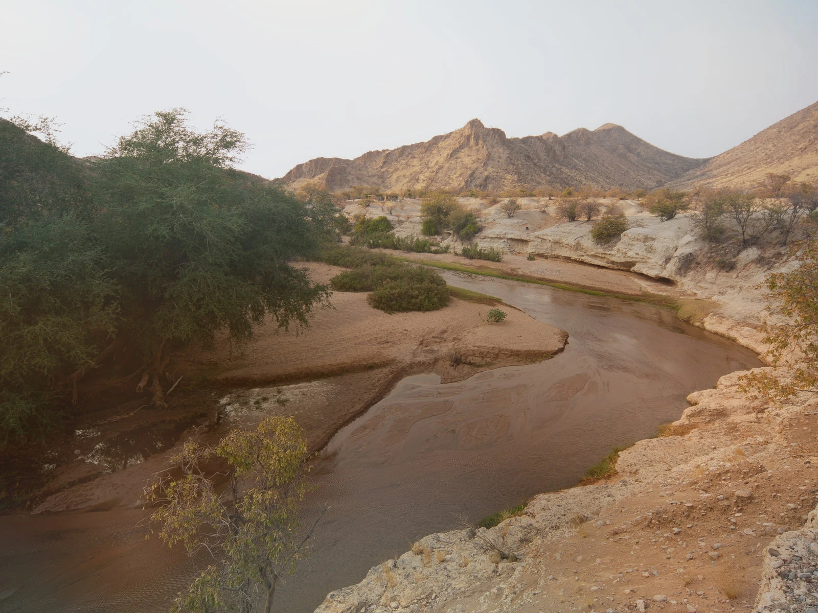 Ein Wasserlauf zwischen den Felsen der trockenen namibischen Landschaft